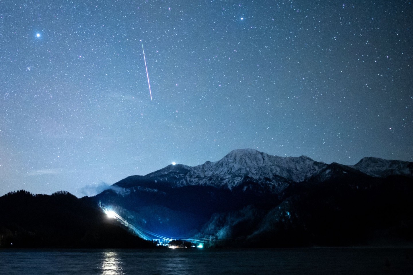 Eine Sternschnuppe ist während der Geminiden über dem Kochelsee zu sehen.