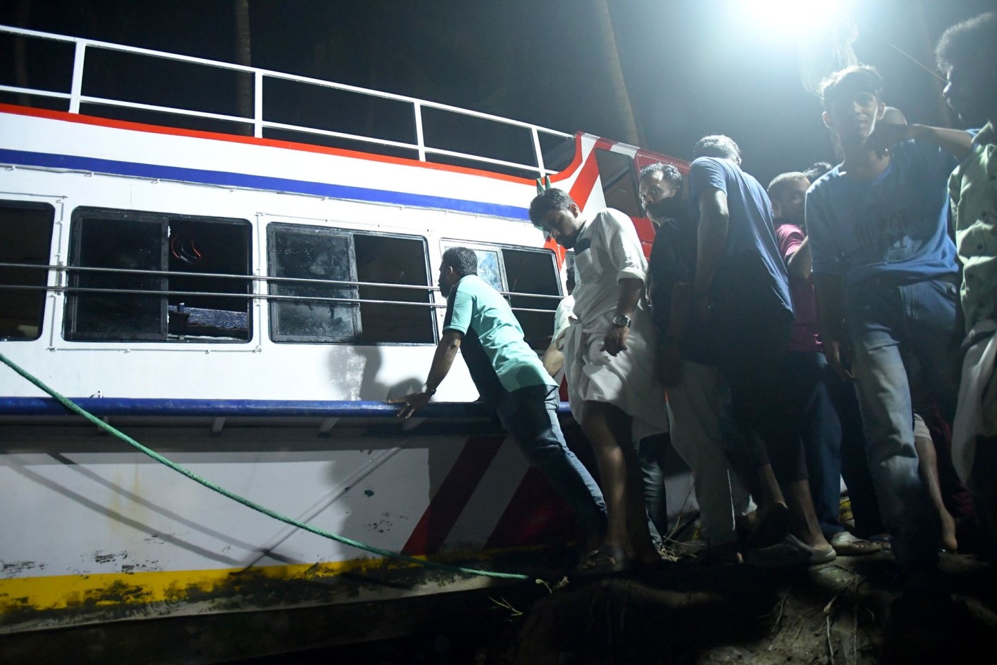 Retter ziehen im indischen Malappuram das Boot an Land, das gekentert ist.