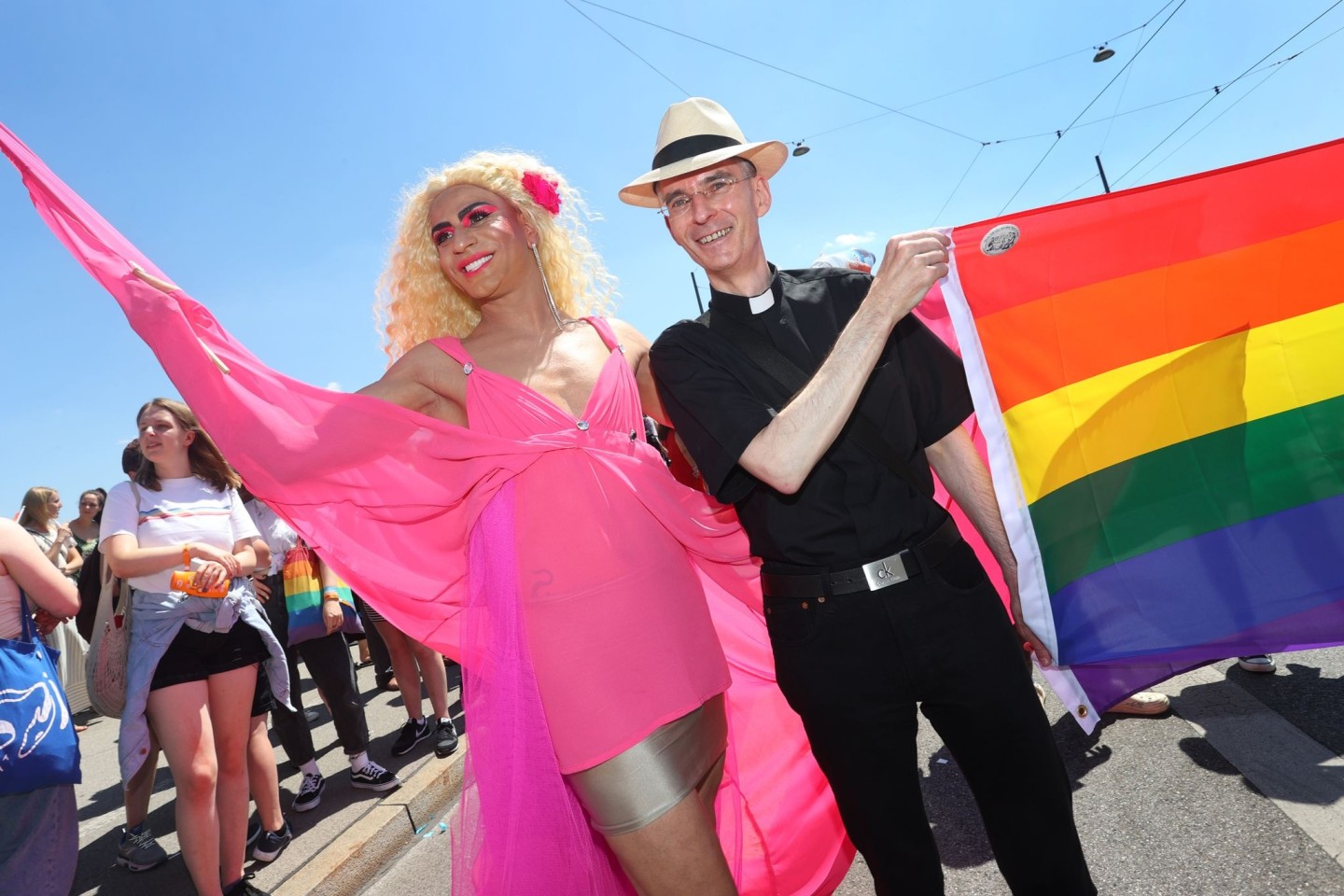 Der katholische Geistliche Wolfgang Rothe (r) nimmt an der Parade anlässlich des Christopher Street Day (CSD) in der Münchner Innenstadt teil.