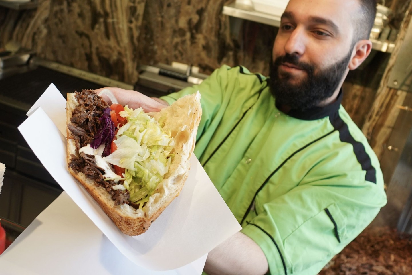 Ein Mitarbeiter eines Grill-Restaurants in Berlin bereitet einen Döner zu.