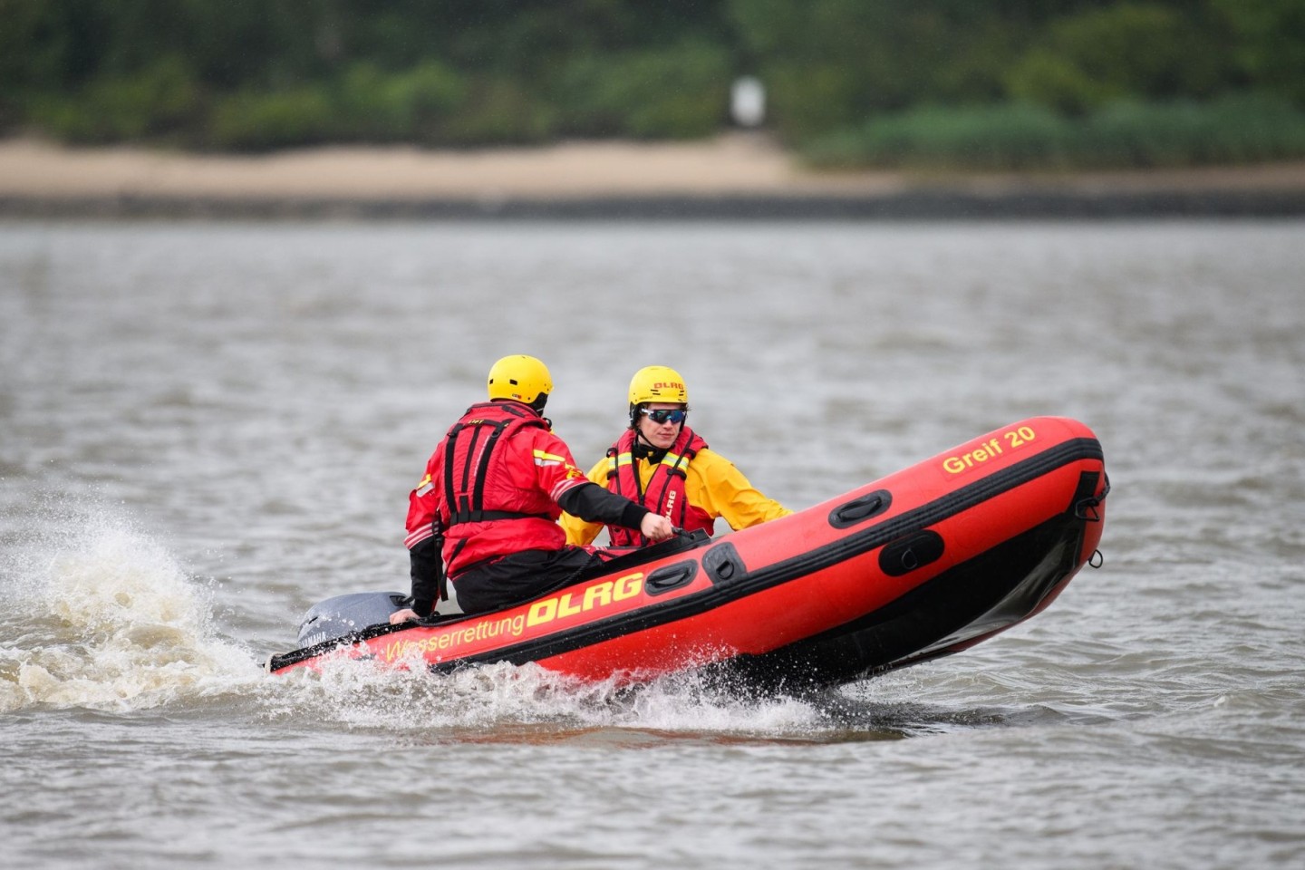 Zwei DLRG-Retter mit einem Schlauchboot auf der Elbe.