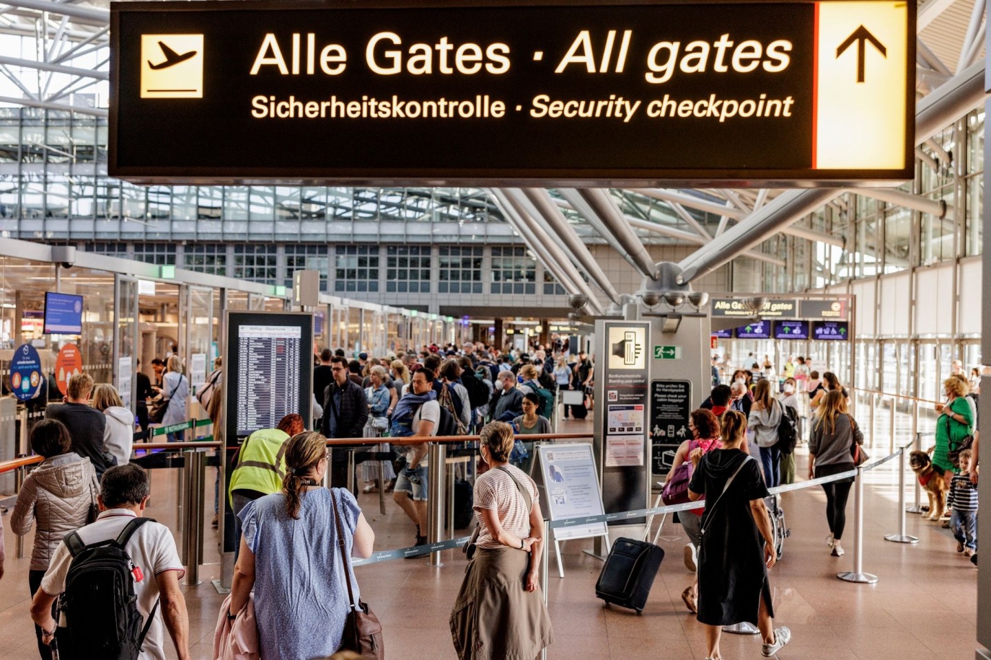 Fluggäste im Helmut Schmidt Flughafen in Hamburg vor dem Sicherheitscheck.