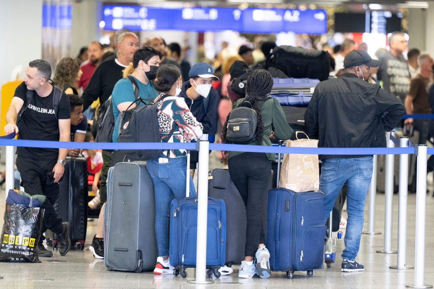 Passagiere warten auf dem Flughafen in Frankfurt am Main auf ihren Check-In.