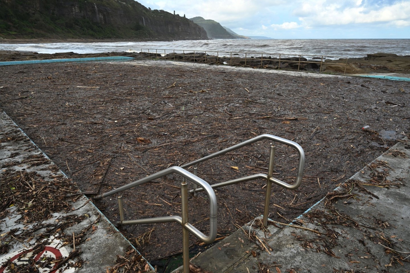 Der Coalcliff Ocean Pool ist nach Sturzfluten und Erdrutschen mit Sturmschutt gefüllt. In Australien häufen sich Todesfälle beim Schwimmen im Pazifik aufgrund starker Strömung.