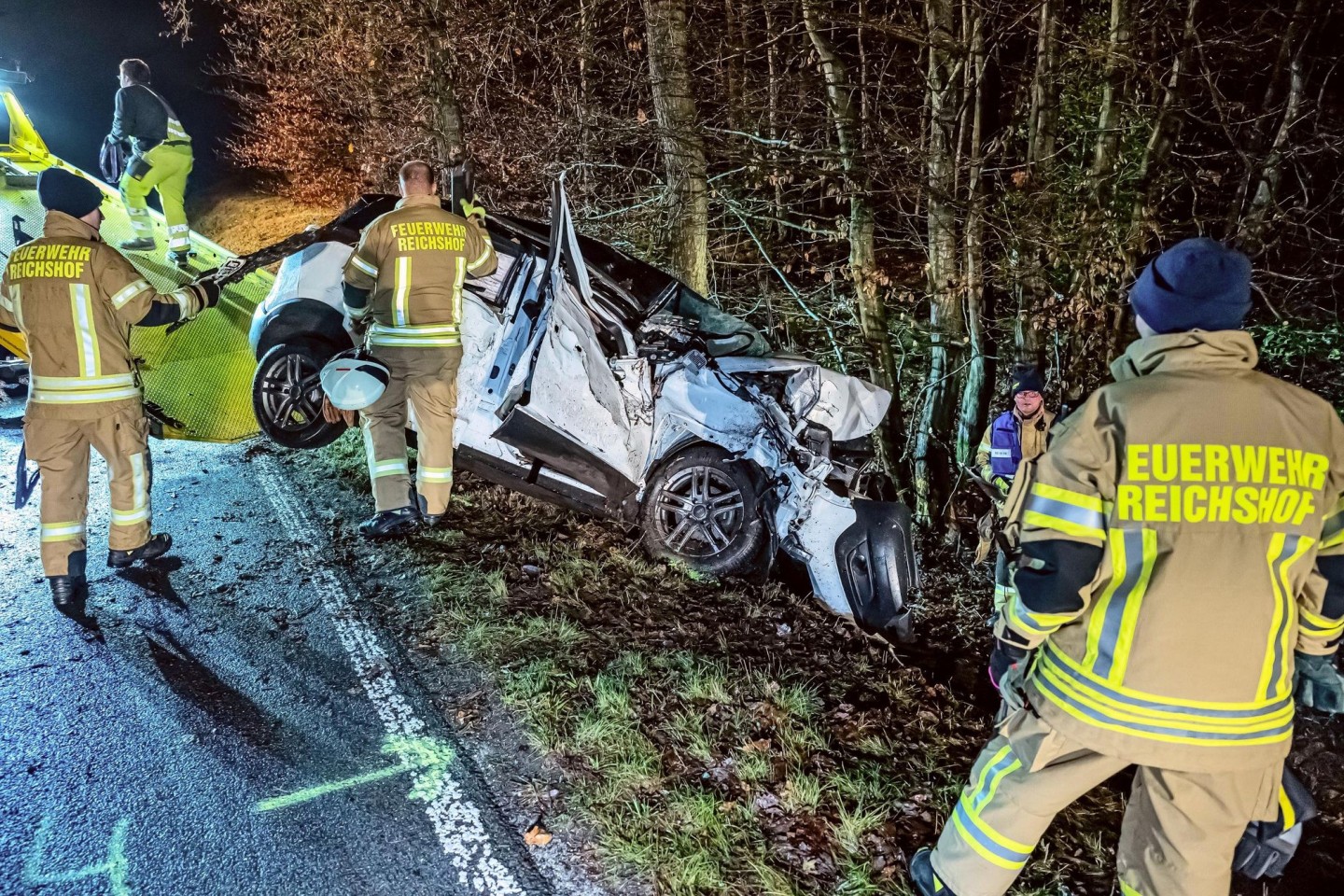 Feuerwehrleute helfen beim Abschleppen des Wracks nach dem Unfall.