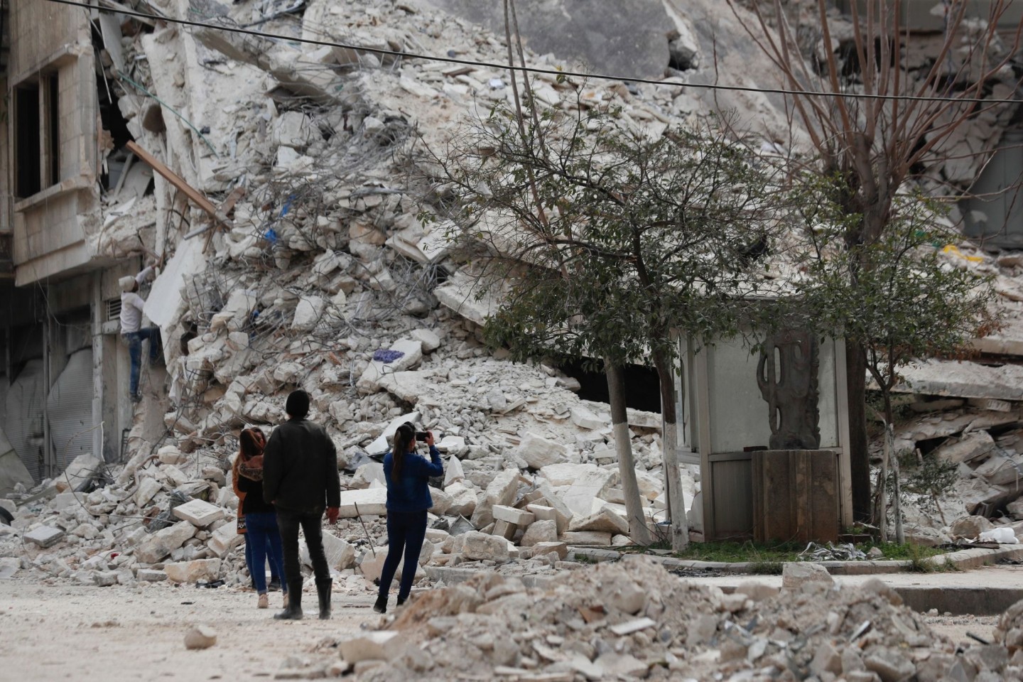 Menschen stehen vor den Trümmern eines Gebäudes, das bei dem jüngsten Erdbeben in Aleppo zerstört wurde.