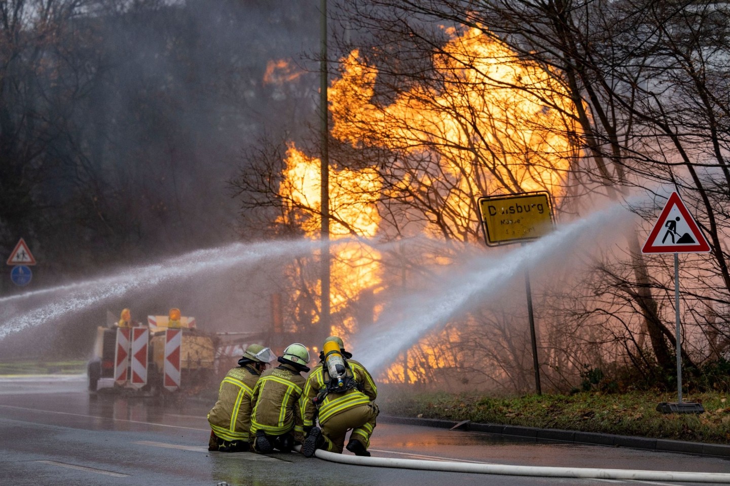 Feuerwehrleute arbeiten daran, ein brennendes Gasleck zu löschen.