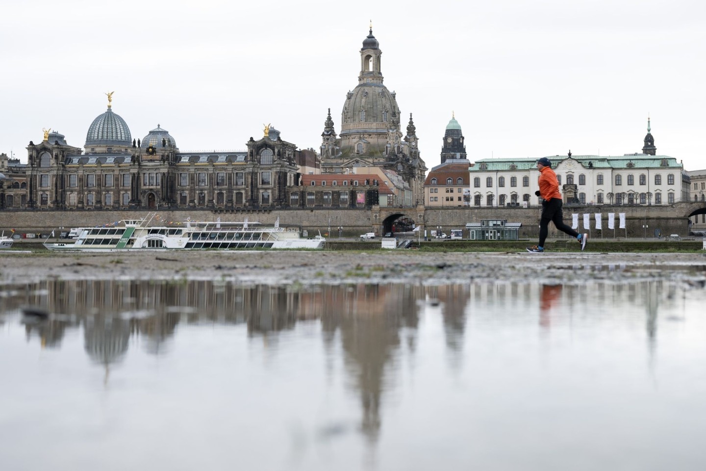 Ein Jogger am Ufer der Elbe vor der Kulisse Dresdens.