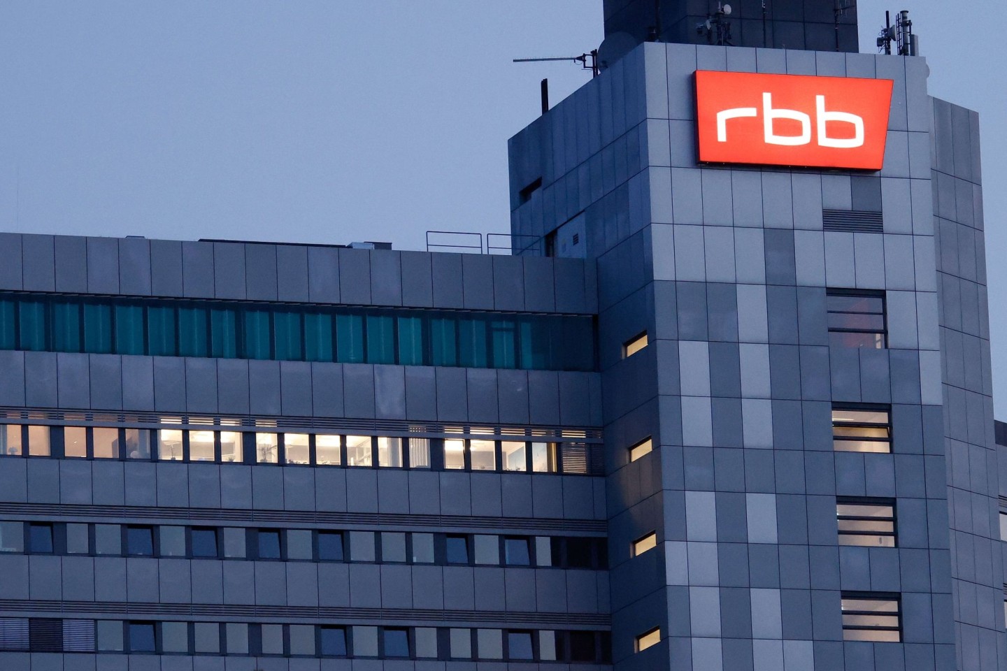 Das beleuchtete Logo des Senders Rundfunk Berlin-Brandenburg (RBB) am Sitz des Senders an der Masurenallee in Berlin.