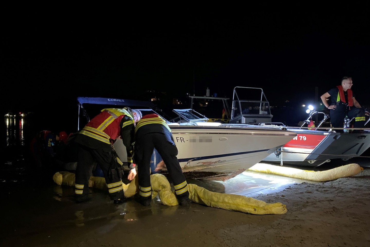 Feuerwehrleute untersuchen das verunglückte Boot.