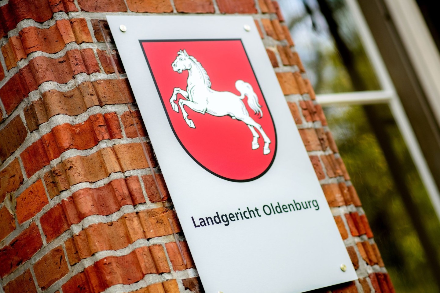 Ein Schild mit dem niedersächsischen Landeswappen hängt am Eingang zum Landgericht Oldenburg: Das Gericht verkündete das Urteil im Prozess gegen Högel-Vorgesetzte.