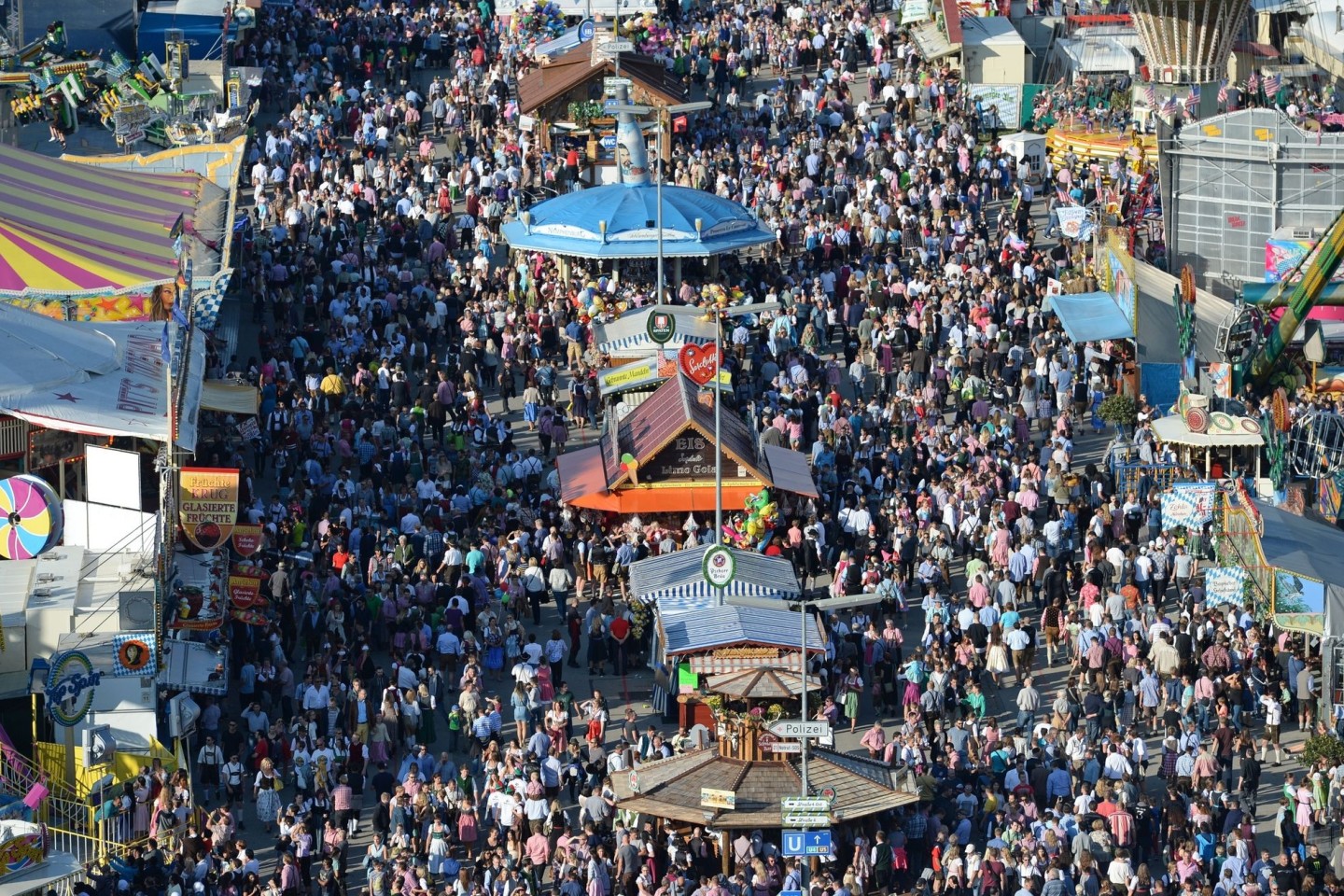 Dich gedrängt schlendern die Besucher bei Sonnenschein über das Oktoberfest-Gelände.