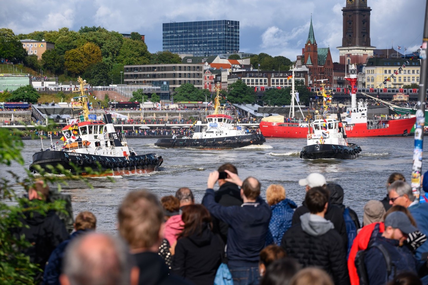 Schaulustige beobachten das traditionelle Schlepperballett auf der Elbe.