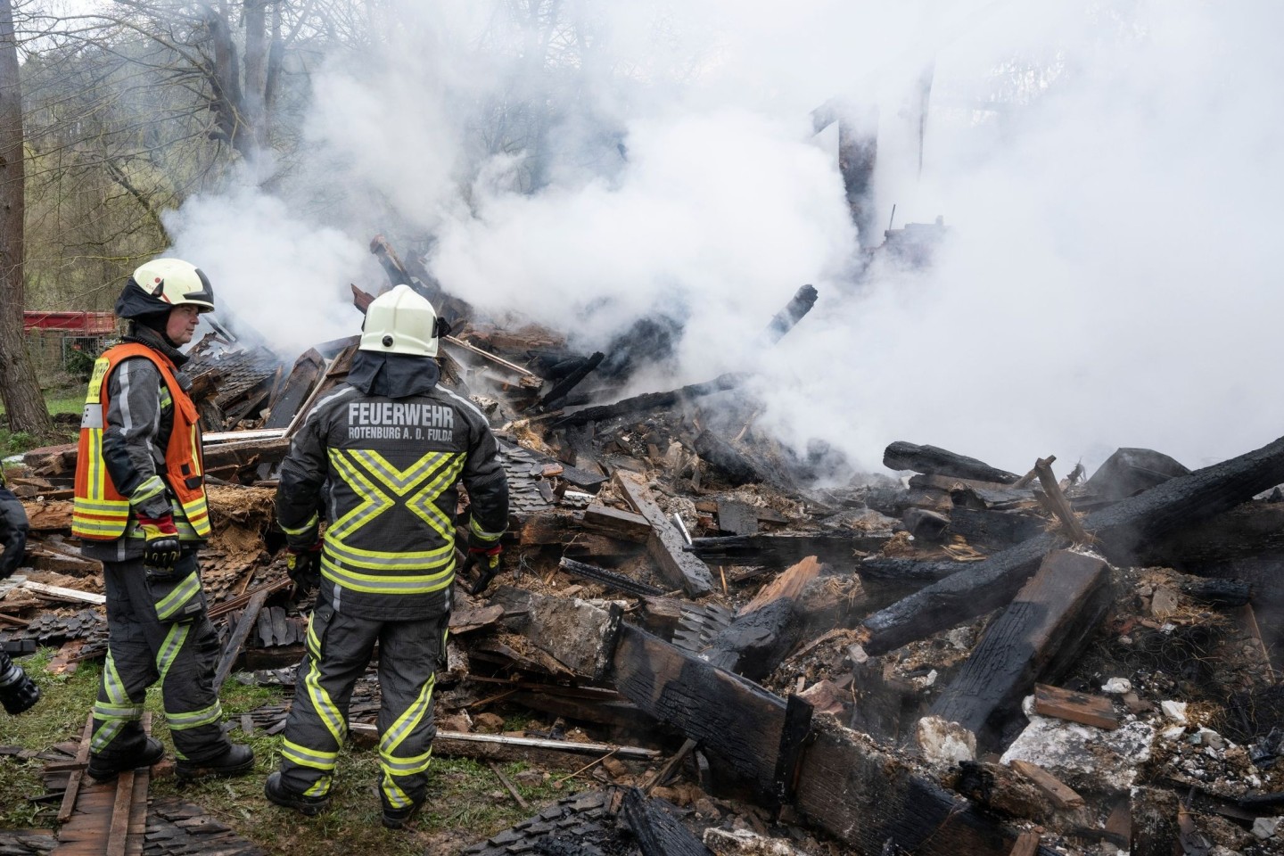 Feuerwehrleute stehen neben den noch rauchenden Trümmern des ehemaligen Hauses des «Kannibalen von Rotenburg».