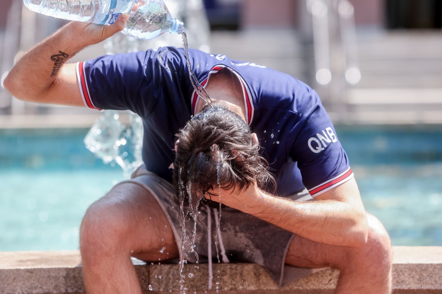 Abkühlung! Ein junger in Madrid übergießt sich mit einer Wasserflasche. Die Hitzewelle in Spanien erreicht nun auch Deutschland.