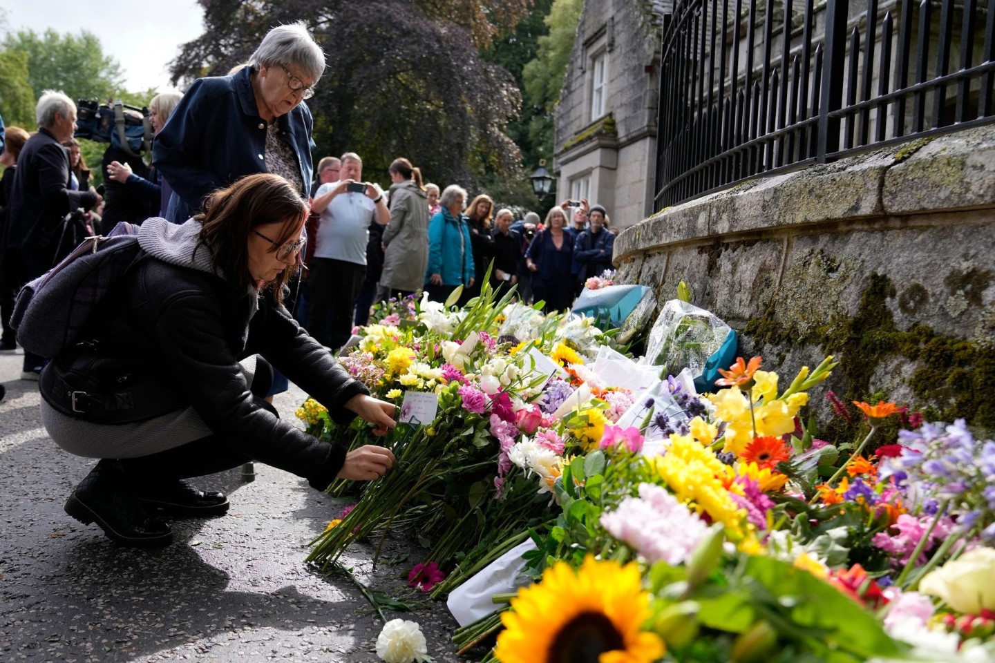 Menschen legen Blumen und letzte Grüße in der Nähe von Schloss Balmoral nieder. Doch nicht alle trauern um die Königin, zumal nicht in ehemaligen Kolonien.