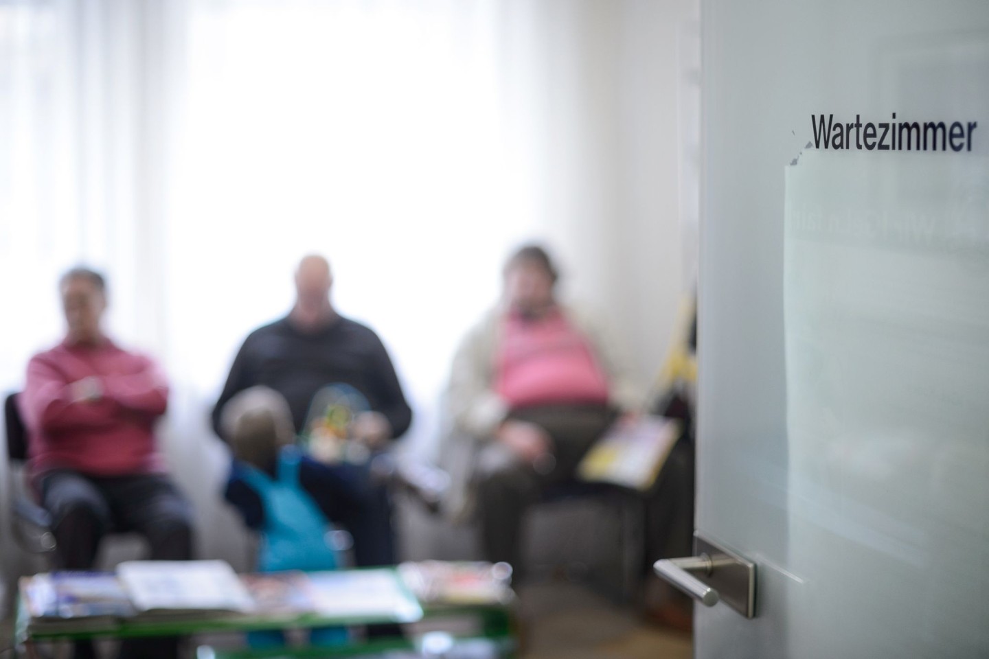 Patienten warten im Wartezimmer einer Arztpraxis.