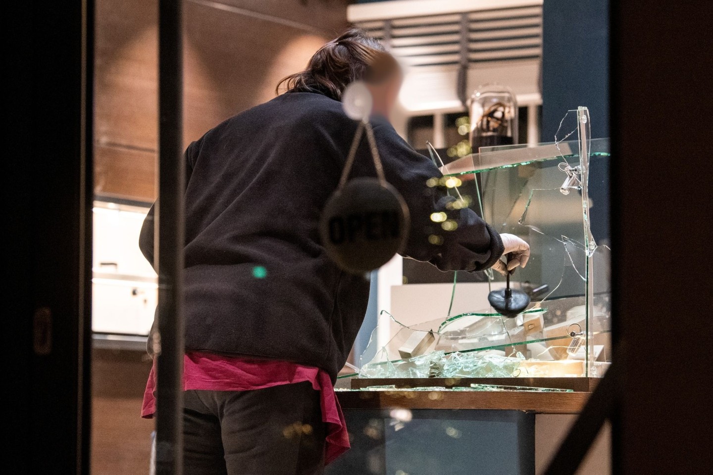 Eine Mitarbeiterin der Spurensicherung untersucht nach dem Überfall in Hamburg eine eingeschlagene Vitrine.