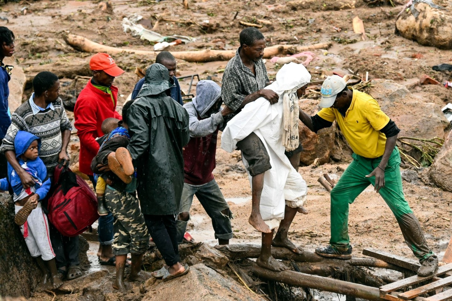 Ein verletzter Mann wird in Malawi über eine Behelfsbrücke getragen.