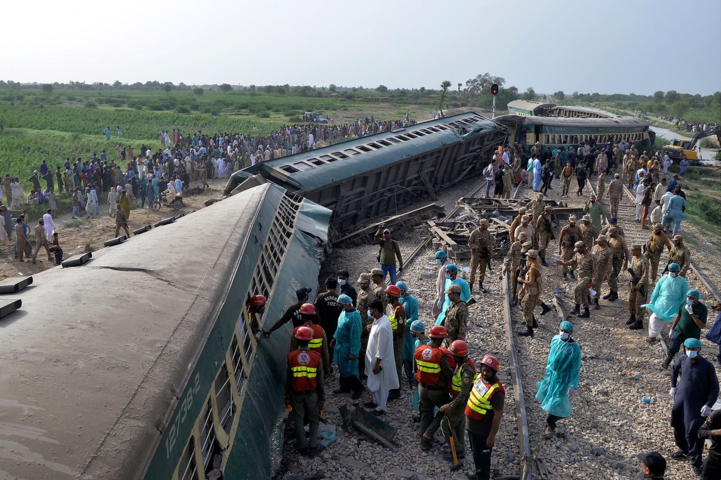 Rettungskräfte und Soldaten versuchen nach dem Unglück in der südpakistanischen Provinz Sindh, Menschen aus dem entgleisten Zug zu befreien.