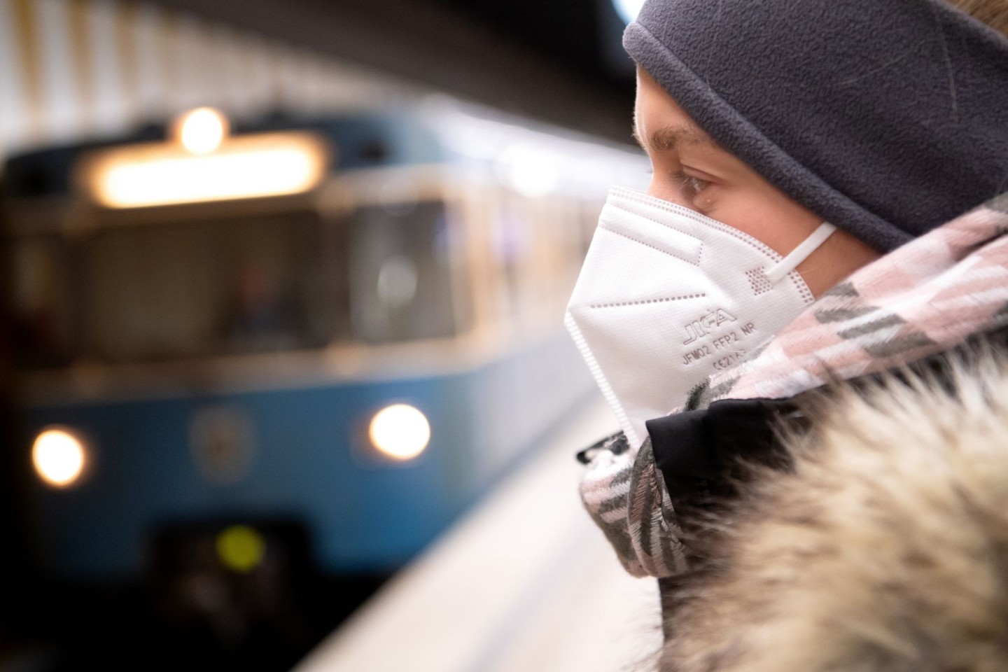 Ein Frau mit FFP2-Maske wartet auf die Bahn.