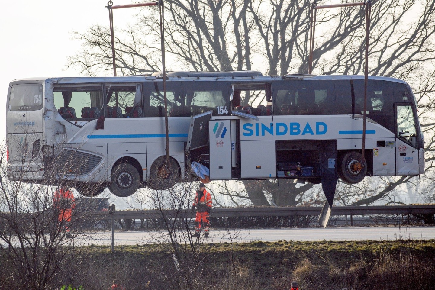 Ein Kran hebt den verunglückten Reisebus zurück auf die Fahrbahn.