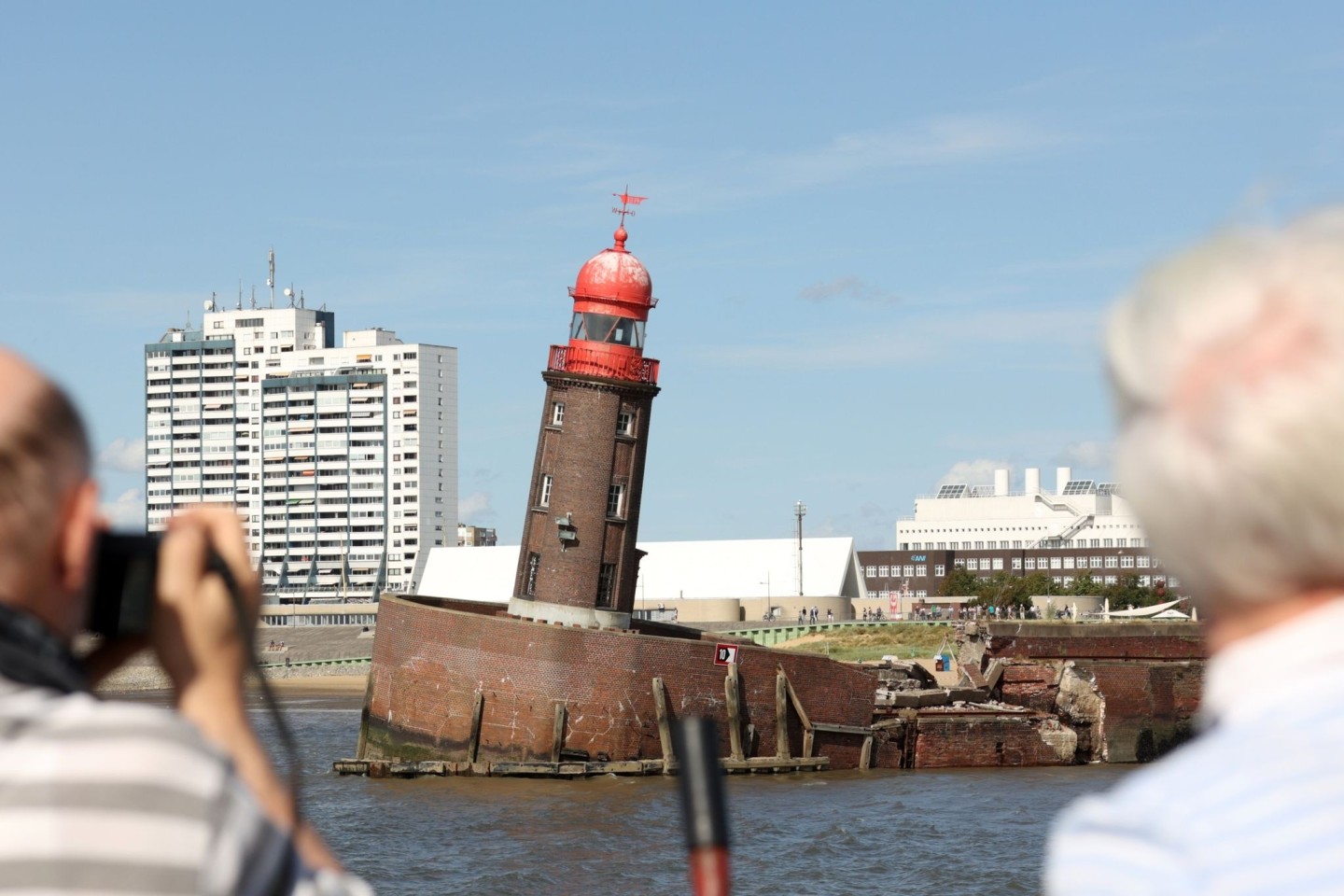 Schaulustige beobachten den abgesackten Moleturm in Bremerhaven.