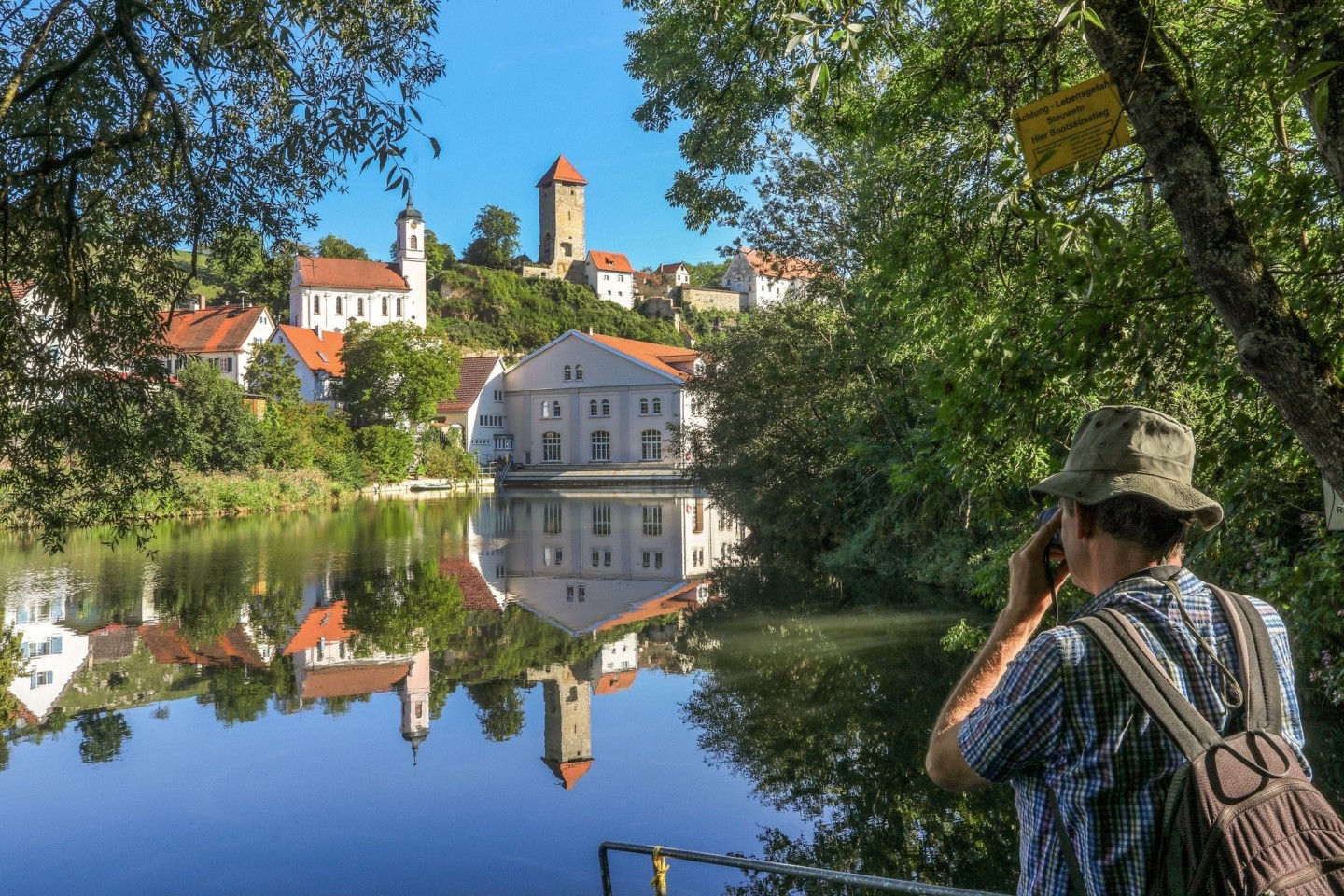 Die Burgruine und die Kirche von Rechtenstein spiegeln sich in der Donau.