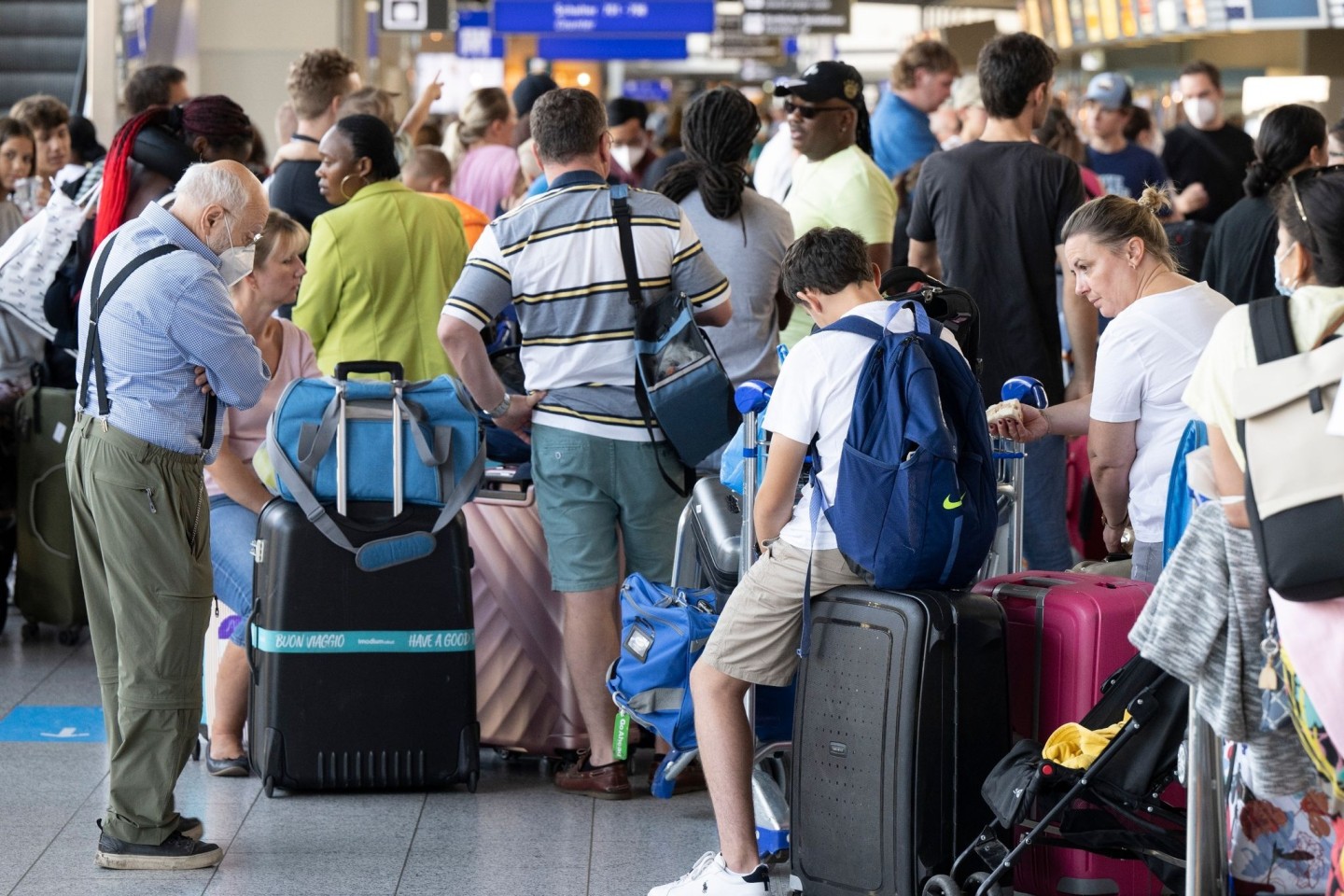 Tausende Passagiere warten vor den Abfertigungsschaltern des Flughafens auf ihren Check-In.