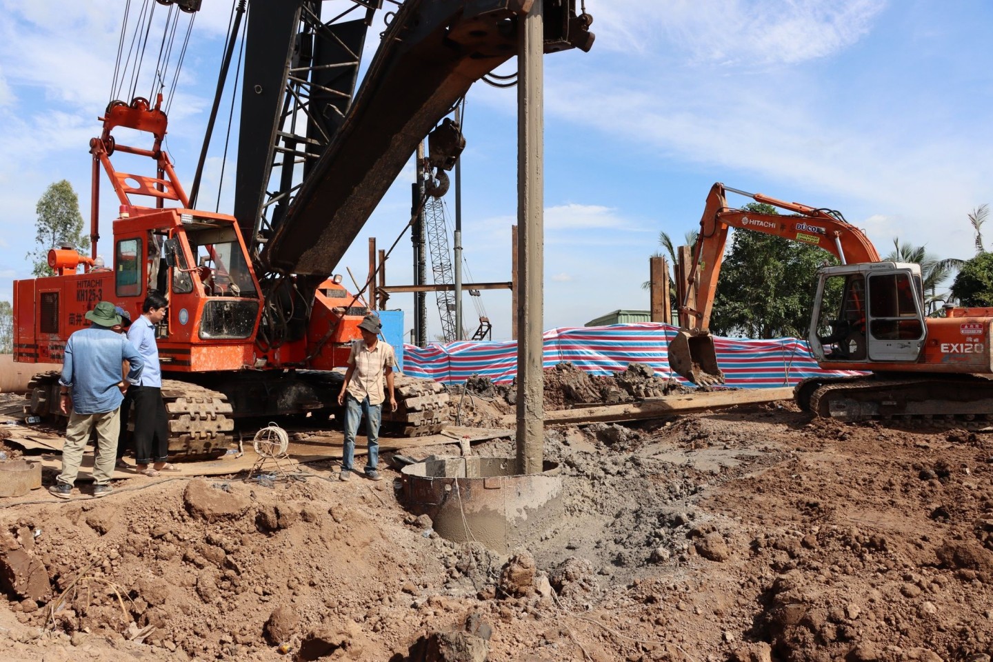 Rettungskräfte stehen an dem Rohr auf einer Baustelle in Vietnam.