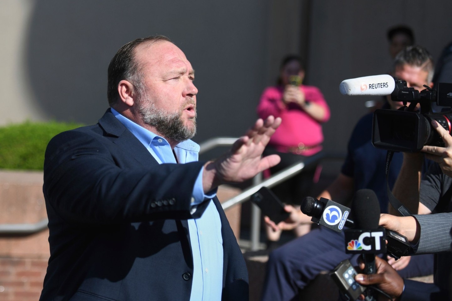 Alex Jones spricht zu Journalisten, bevor er das Gericht in Waterbury betritt.