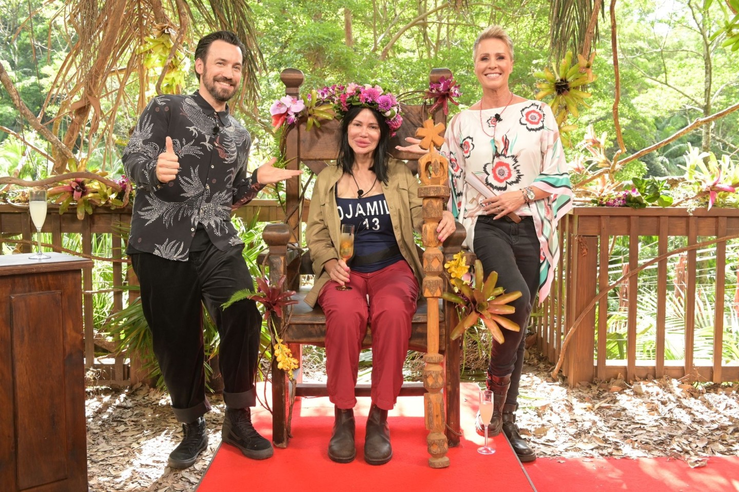 Djamila Rowe sitzt nach dem Sieg beim RTL-Dschungelcamp 2023 mit ihrer Krone auf ihrem Thron. Neben ihr stehen Moderatorin Sonja Zietlow (r) und Moderator Jan Köppen.