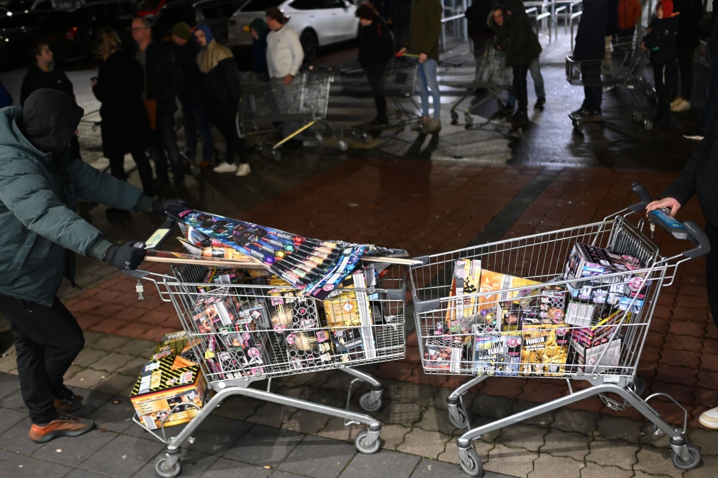 Junge Niederländer sind extra angereist, um zu Beginn des Verkaufs von Silvesterfeuerwerk bei einem Discounter in der Grenzregion deutsches Feuerwerk einzukaufen.