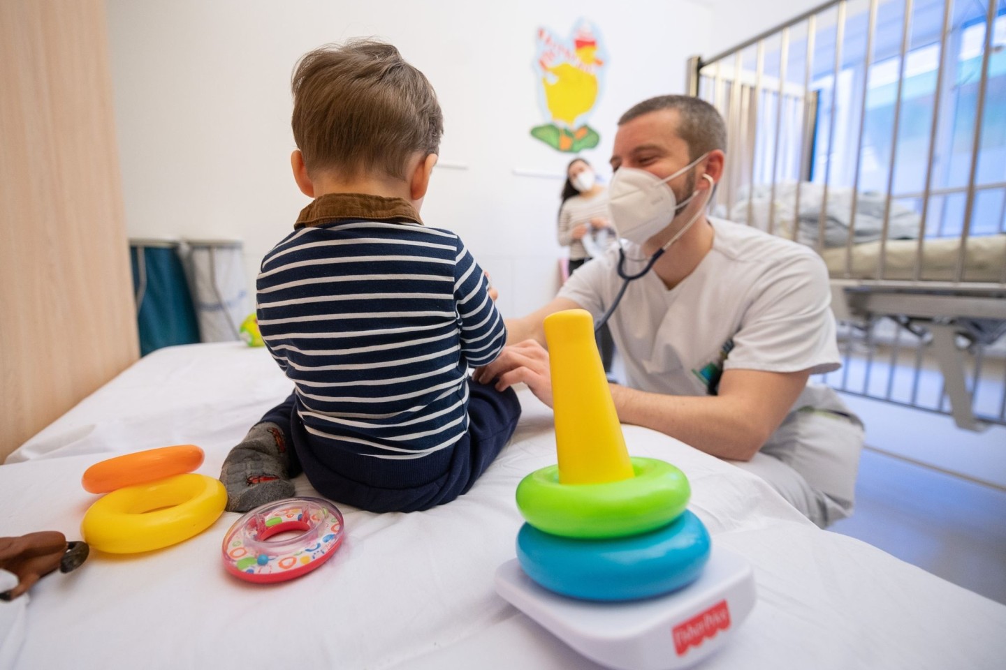 Ein Arzt untersucht in einer Kinderklinik ein Kind.