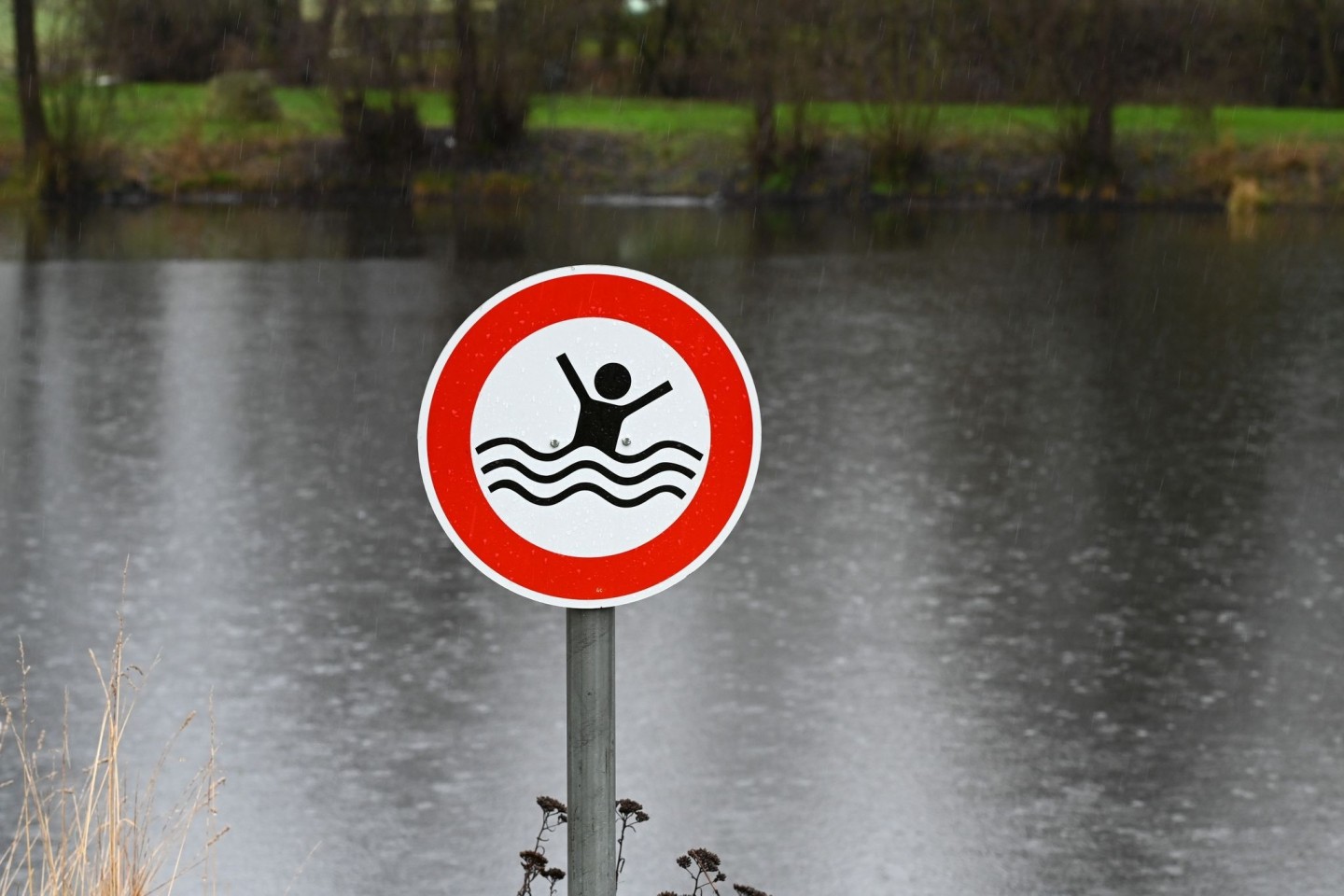 Ein Schild warnt am Löschteich von Seigertshausen in Hessen vor der Gefahr des Ertrinkens.