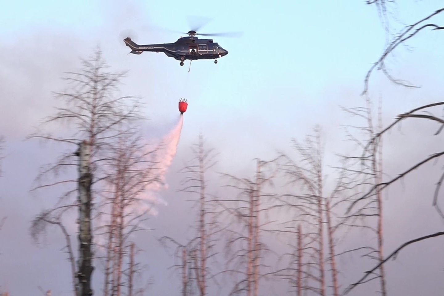 Ein Löschhubschrauber über dem Waldbrand in einem munitionsbelasteten Gebiet bei Jüterbog (Landkreis Teltow-Fläming).