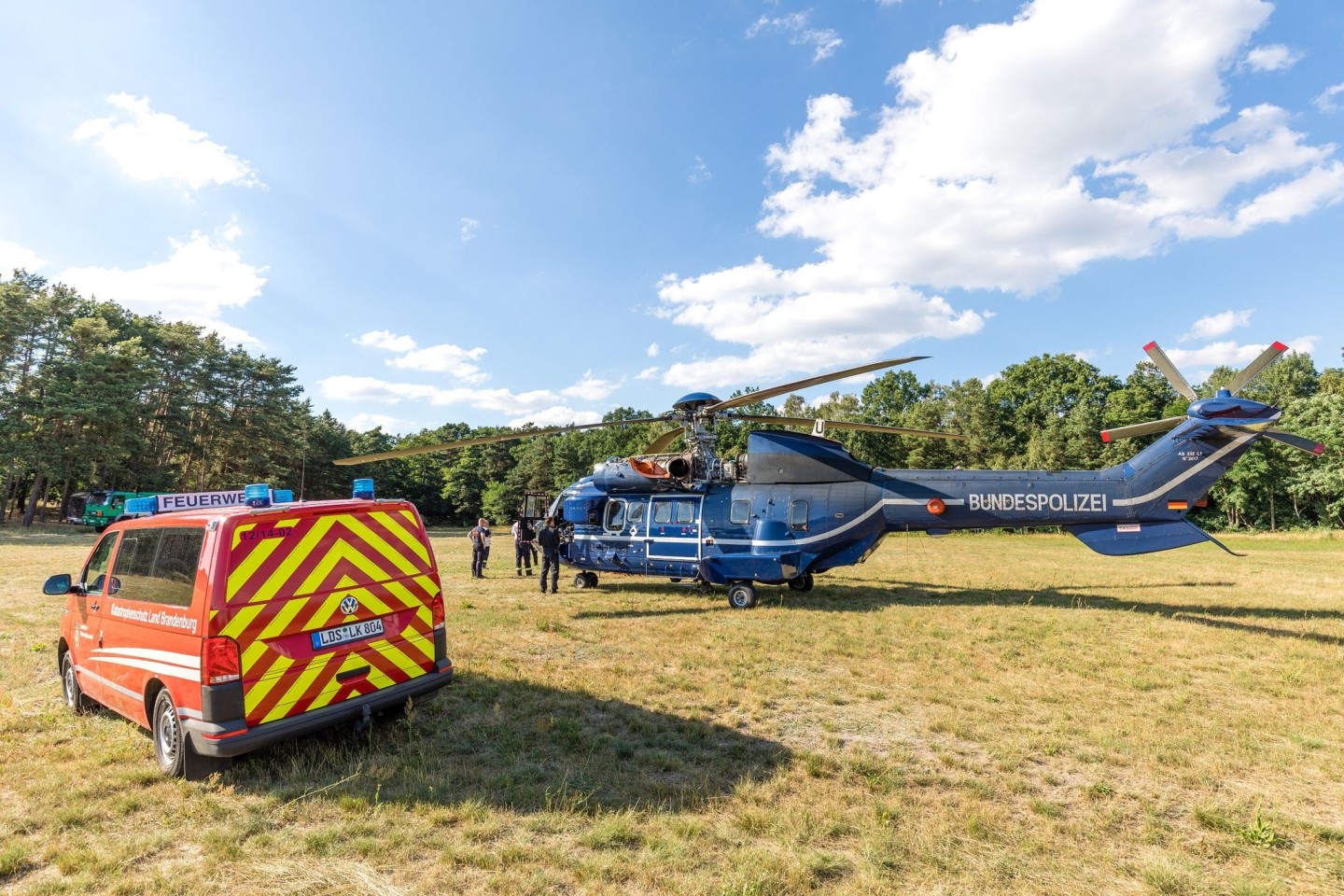 Ein Löschhubschrauber der Bundespolizei auf einer Wiese in der Lieberoser Heide.