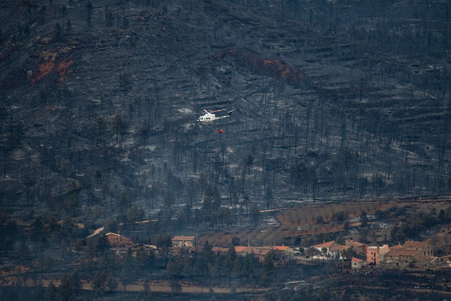 Ein Hubschrauber fliegt in San Agustin über ein verbranntes Gebiet. Vom Wald ist nicht mehr viel übrig.