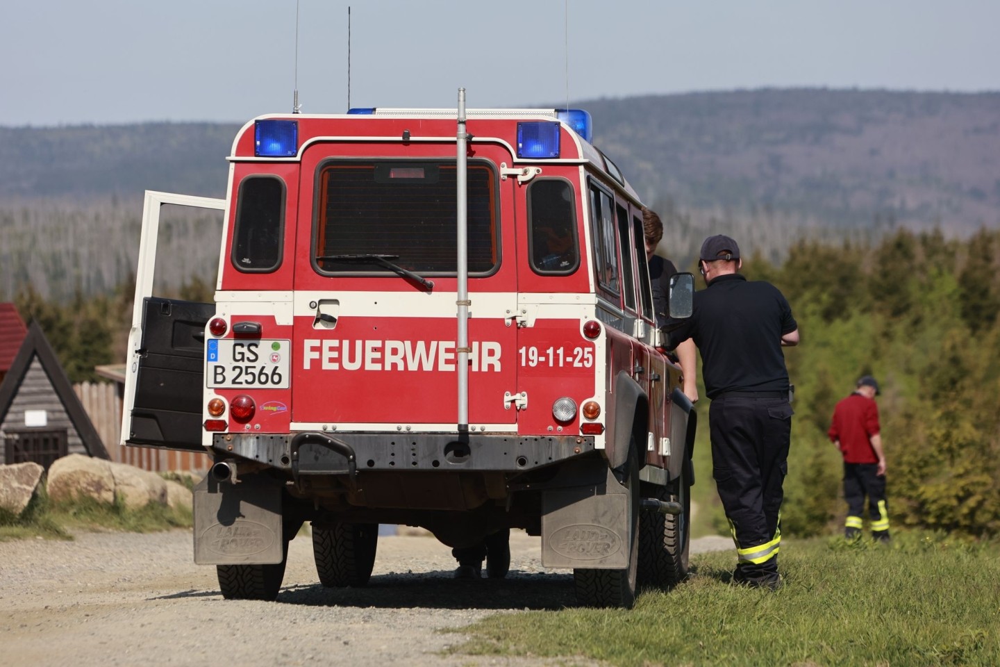 Einsatzkräfte der Feuerwehr beobachten vom niedersächsischen Wurmberg aus das Waldbrandgebiet am Brocken.