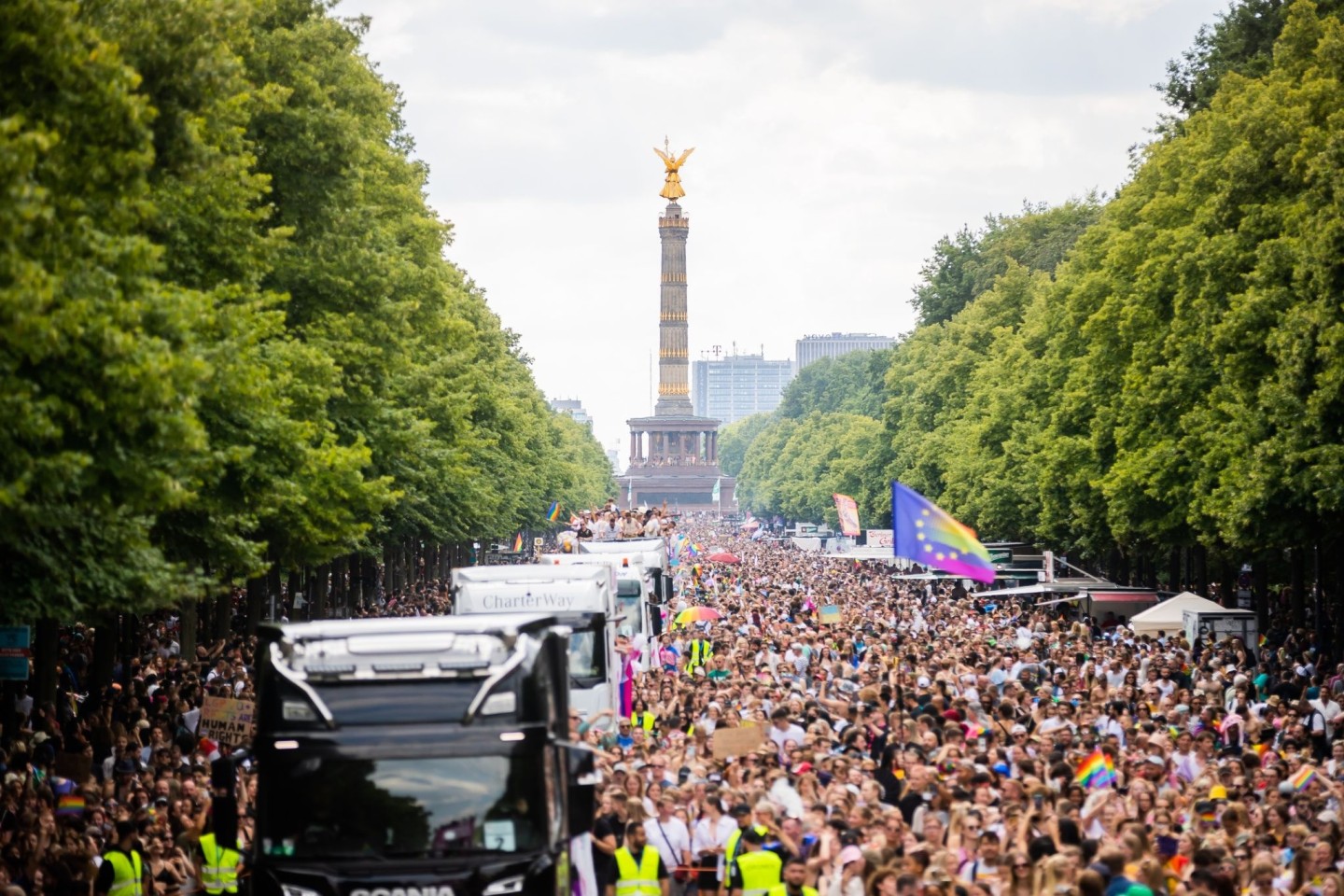 Der Zug des Christopher Street Day (CSD) zieht über die Straße des 17. Juni. Im Hintergrund: die Siegessäule.