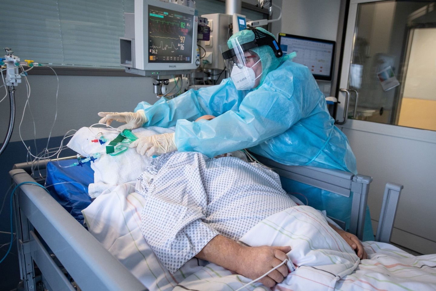 Eine Intensiv-Pflegerin versorgt einen schwer an Corona erkrankten Patienten auf der Intensivstation des Klinikums in Fulda.