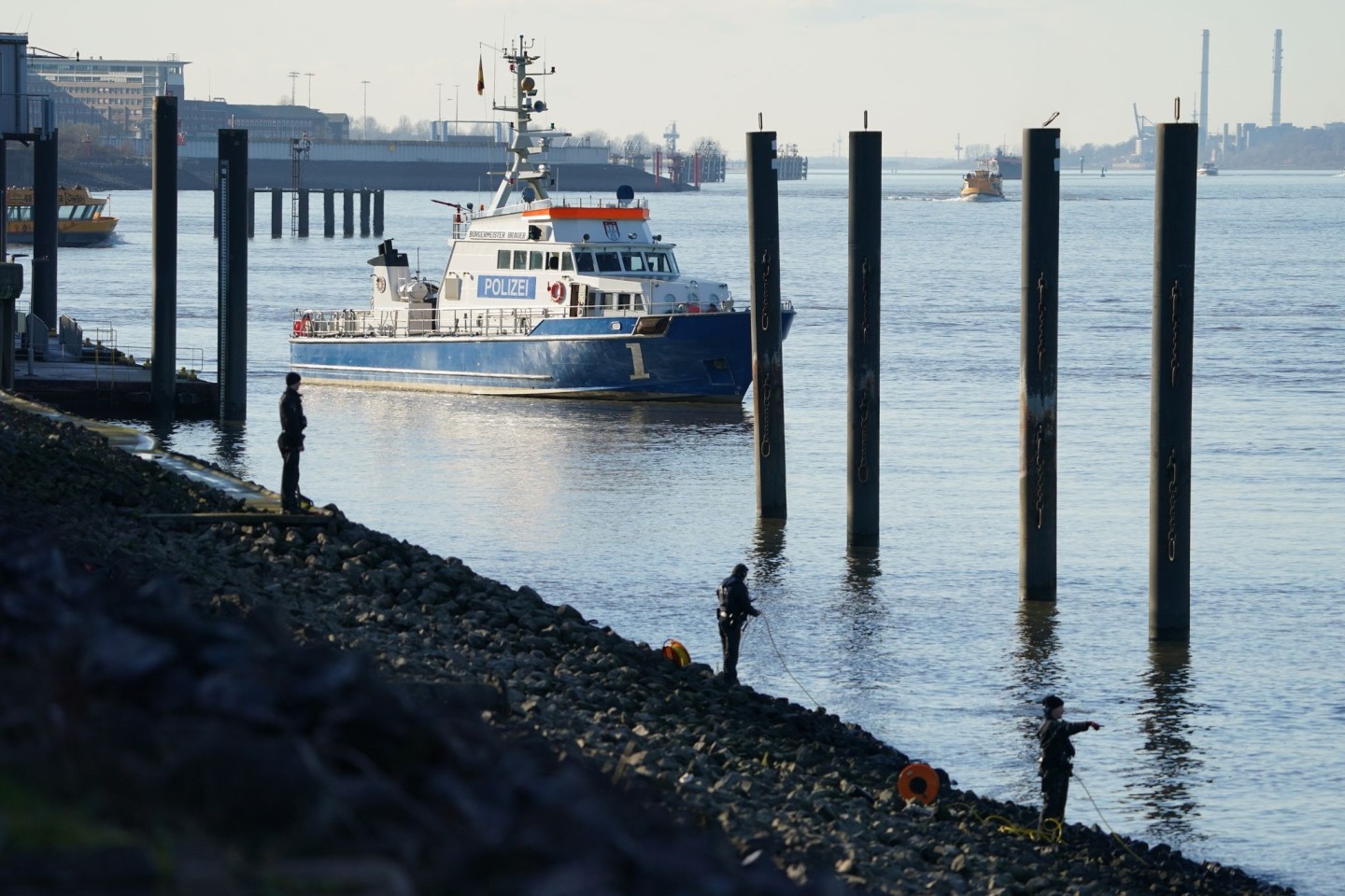 Polizeitaucher und Polizeibeamte bei der Suche nach dem Jungen in der Elbe.